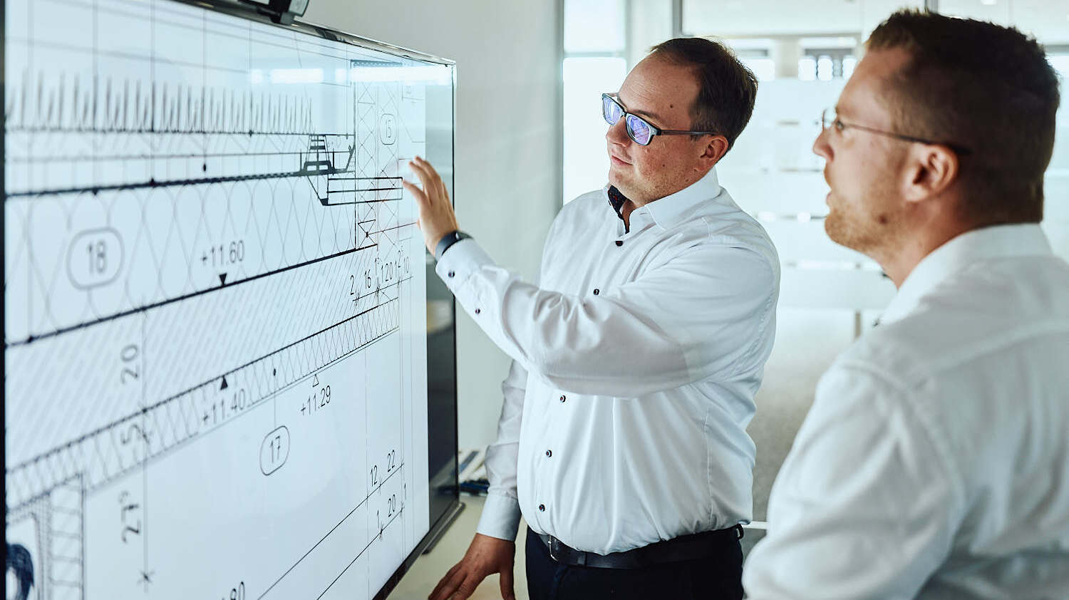 Ein Experte bei IMBRO Immobilien erklärt komplexe technische Details