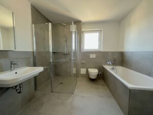 Badezimmer mit Dusche und Wanne